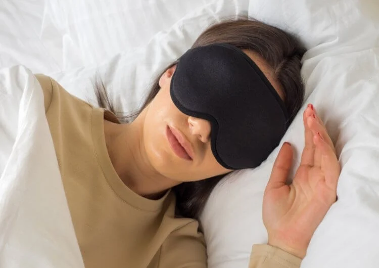 Девушка спит в маске для сна